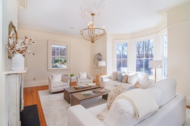 living room with a notable chandelier, crown molding, baseboards, and wood finished floors