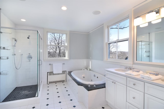 bathroom featuring tile walls, vanity, a jetted tub, a shower stall, and radiator heating unit