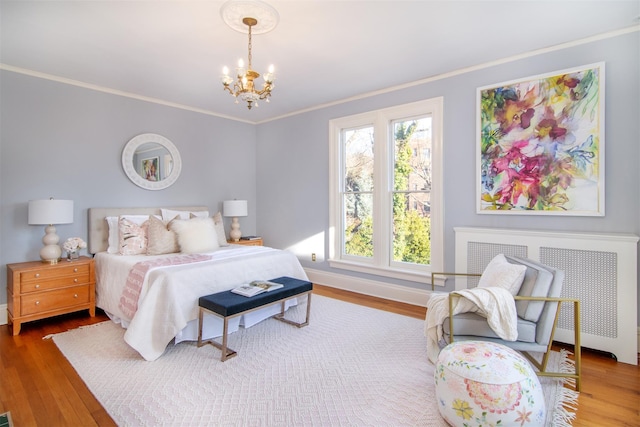 bedroom with a chandelier, crown molding, baseboards, and wood finished floors