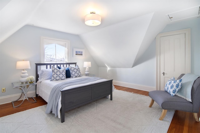 bedroom with light wood-style floors, vaulted ceiling, and baseboards