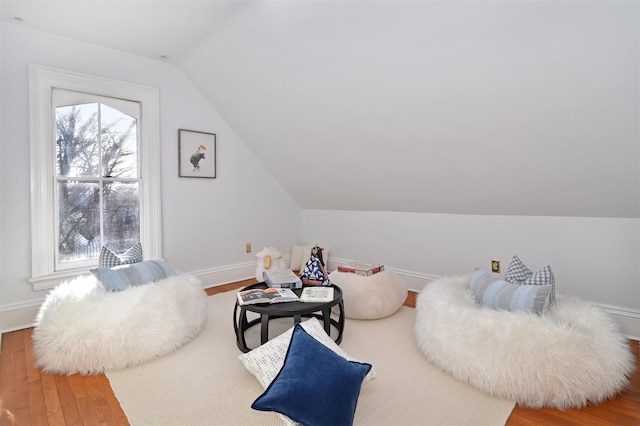 living area with lofted ceiling, wood finished floors, and baseboards