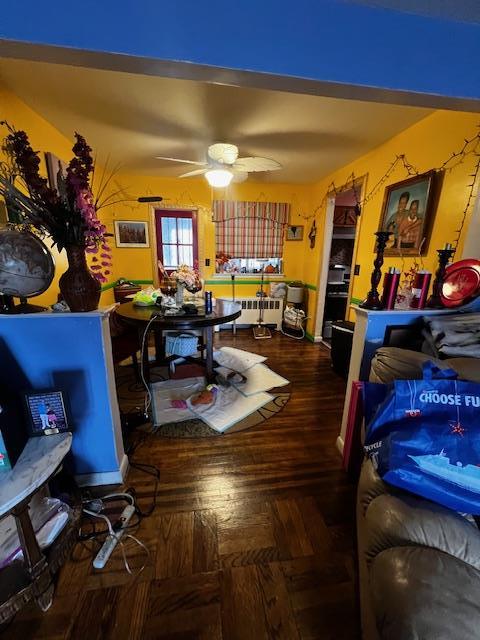 interior space featuring radiator, a ceiling fan, and wood finished floors