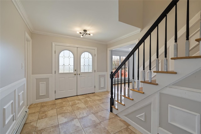 entryway featuring crown molding, a wainscoted wall, a decorative wall, and stairs