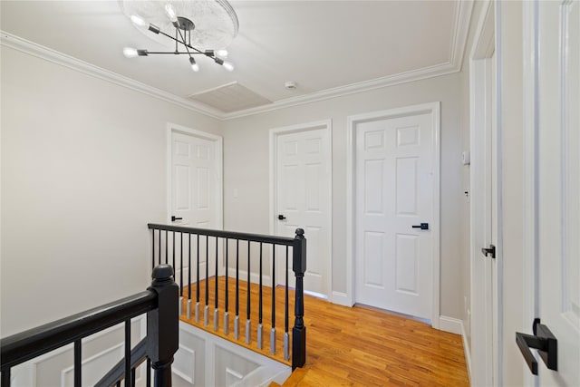 corridor featuring ornamental molding, light wood finished floors, and an upstairs landing