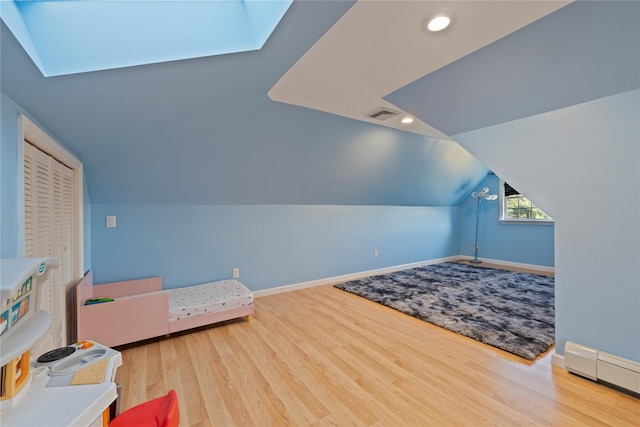 bedroom featuring baseboards, visible vents, wood finished floors, a baseboard heating unit, and recessed lighting