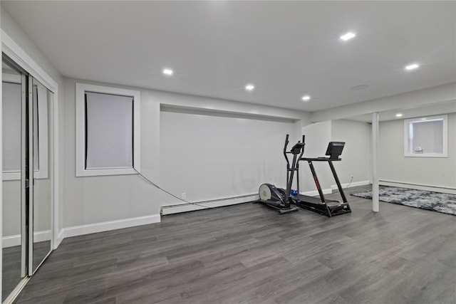 workout area featuring recessed lighting, a baseboard heating unit, wood finished floors, baseboards, and baseboard heating