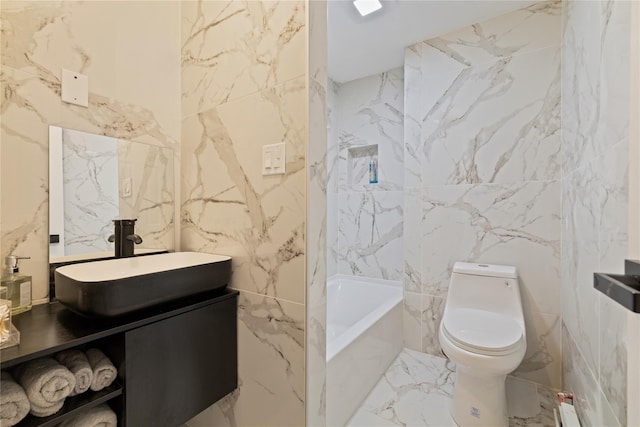 full bath featuring marble finish floor, vanity, toilet, and stone wall