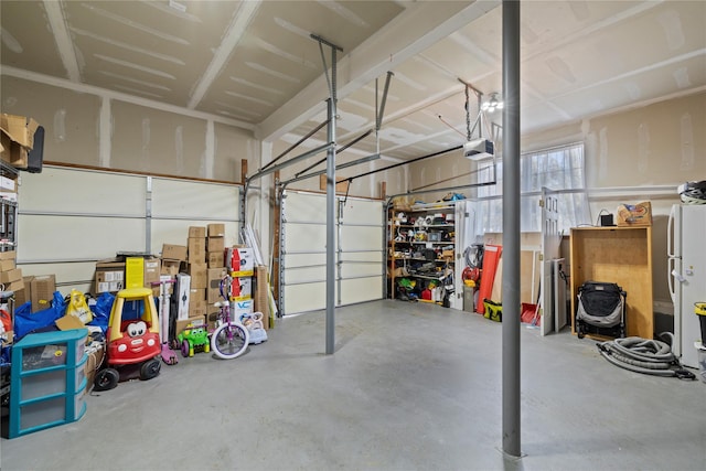 garage featuring a garage door opener and freestanding refrigerator