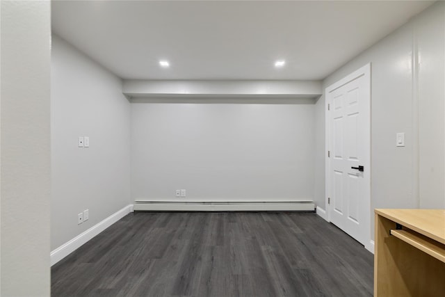 below grade area with dark wood-style floors, a baseboard radiator, and baseboards