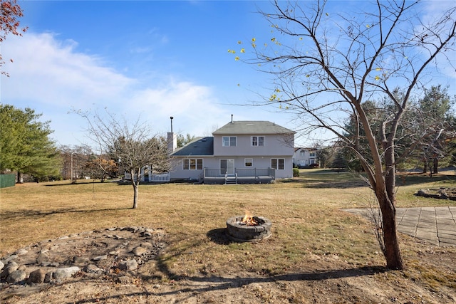 view of front of property featuring a fire pit, a front lawn, and a chimney