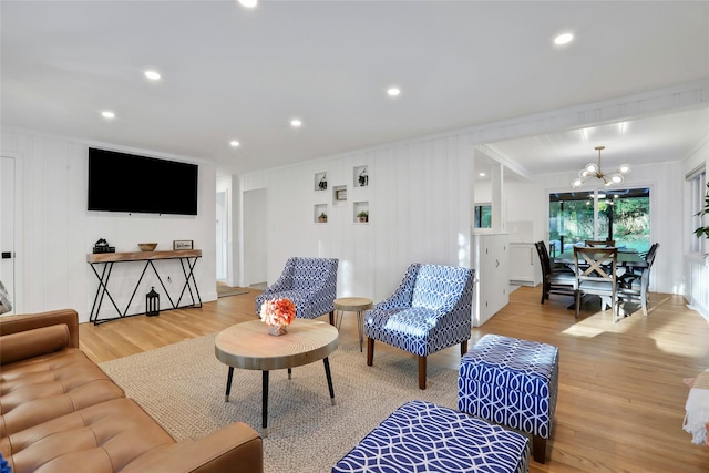 living room with light wood-type flooring, a notable chandelier, and recessed lighting