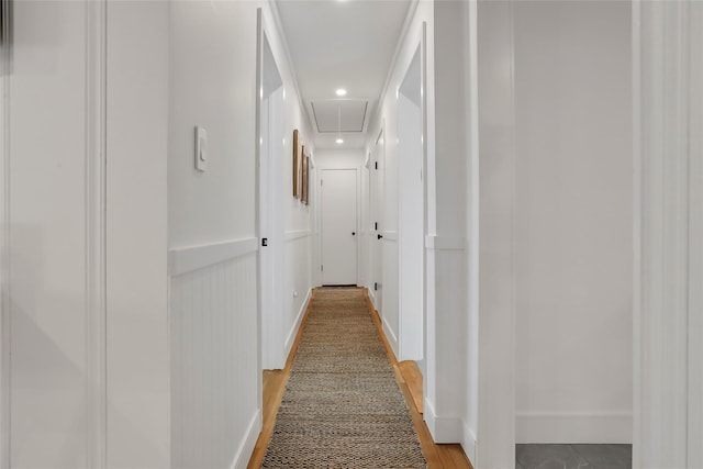 hall with attic access, recessed lighting, and baseboards