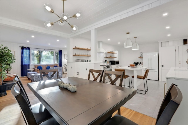 dining area with a chandelier, recessed lighting, and light wood-type flooring