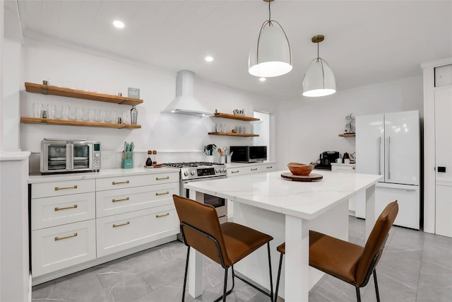 kitchen featuring stainless steel appliances, white cabinetry, wall chimney range hood, and open shelves