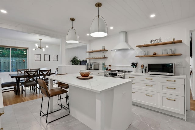 kitchen featuring white cabinets, a kitchen island, appliances with stainless steel finishes, premium range hood, and open shelves