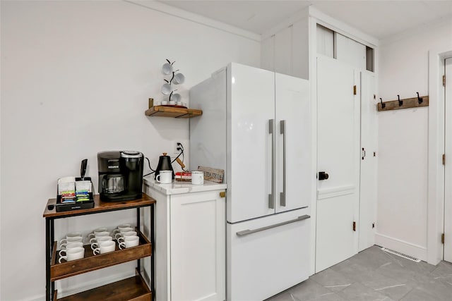 kitchen featuring freestanding refrigerator, white cabinets, light countertops, and open shelves