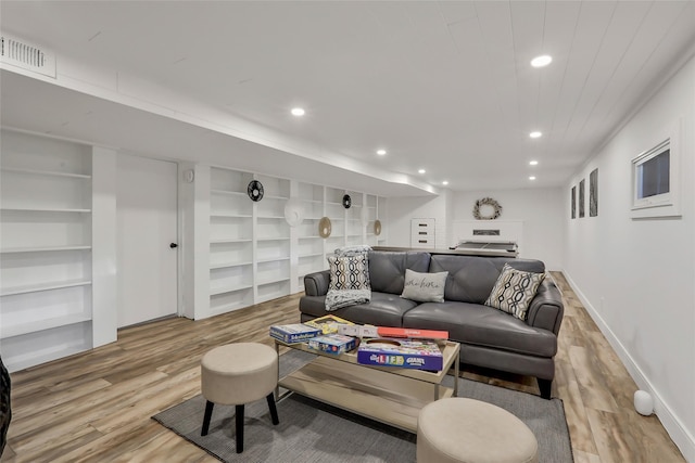 living room featuring built in shelves, recessed lighting, visible vents, light wood-style flooring, and baseboards