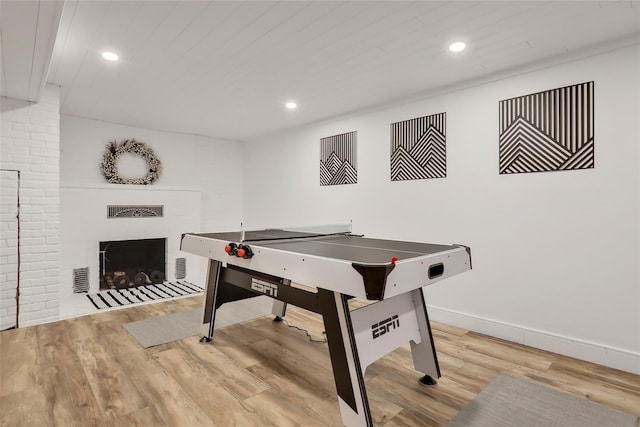 game room with a fireplace with flush hearth, recessed lighting, and wood finished floors