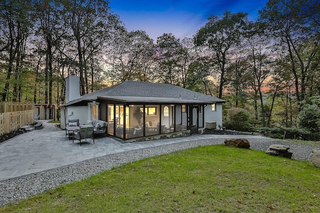 back of property with a patio, fence, a lawn, stucco siding, and a chimney