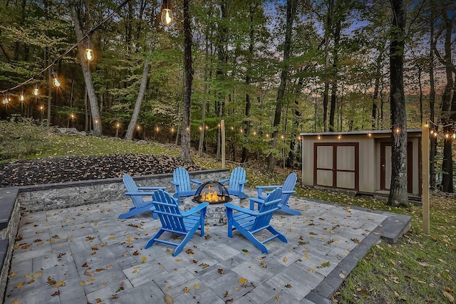 view of patio / terrace with a fire pit, a storage shed, and an outdoor structure