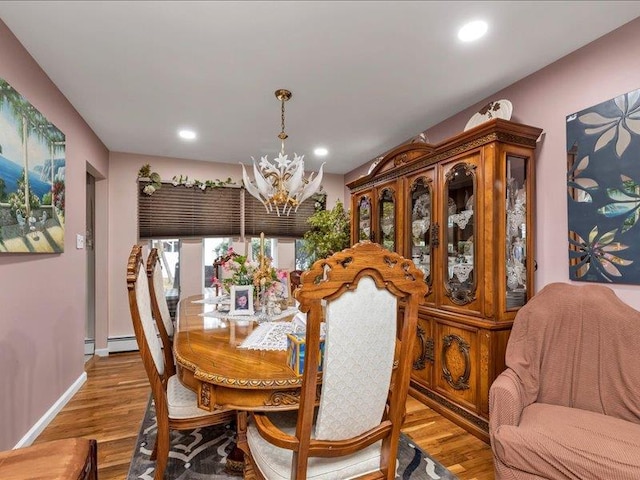 dining room with a chandelier, baseboards, wood finished floors, and recessed lighting