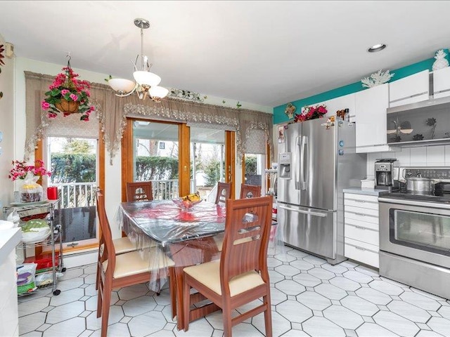 dining room with light floors and a notable chandelier