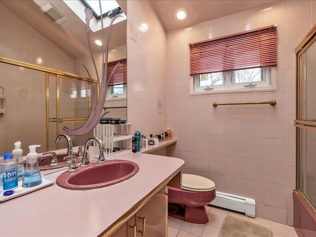 bathroom with tile patterned flooring, toilet, tile walls, baseboard heating, and a tile shower