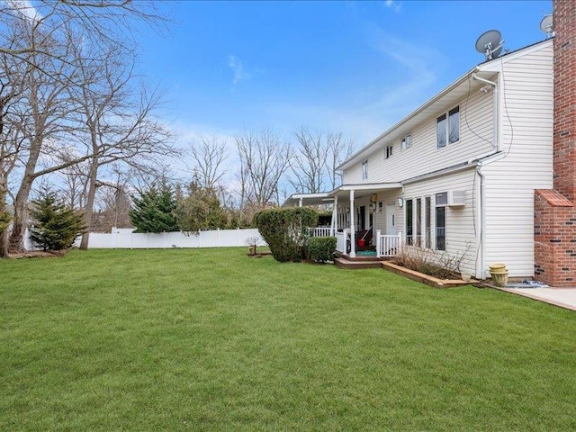 view of yard featuring covered porch and fence