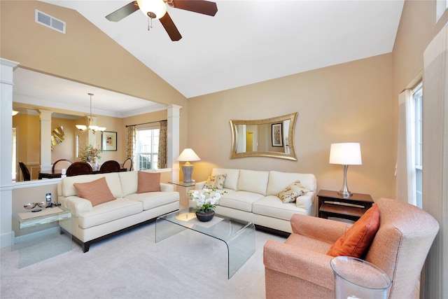 living area with ceiling fan with notable chandelier, visible vents, vaulted ceiling, carpet, and ornate columns