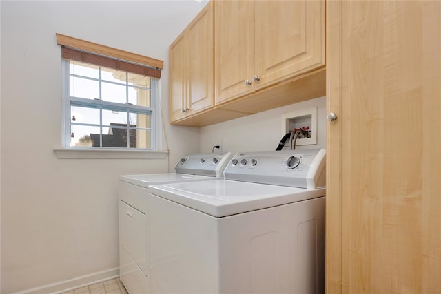 clothes washing area featuring cabinet space, baseboards, and washing machine and clothes dryer