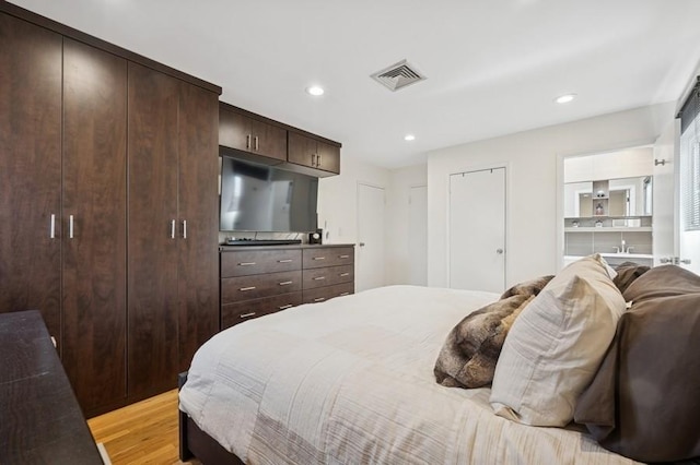 bedroom featuring light wood finished floors, visible vents, and recessed lighting