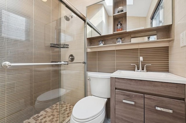 full bathroom with toilet, a stall shower, and vanity