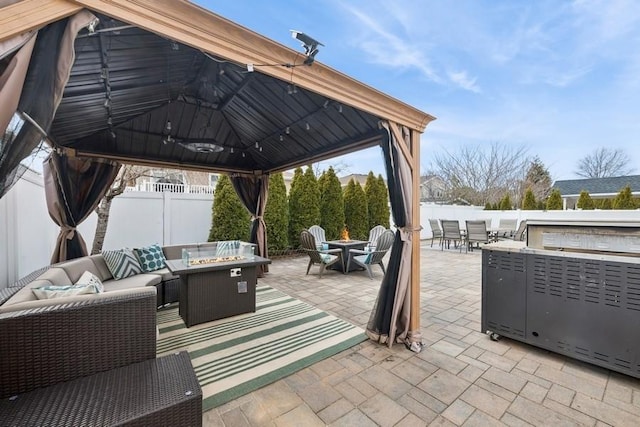 view of patio with a gazebo, an outdoor living space with a fire pit, outdoor dining area, and a fenced backyard