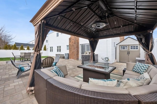 view of patio / terrace with outdoor dining space, an outdoor living space with a fire pit, a gazebo, an outdoor structure, and a storage unit