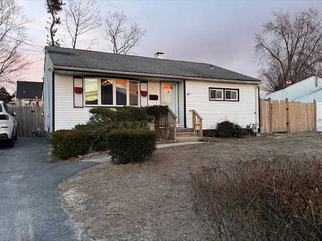 view of front of home featuring aphalt driveway and fence