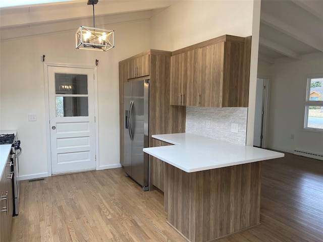 kitchen with brown cabinets, light countertops, appliances with stainless steel finishes, modern cabinets, and a peninsula