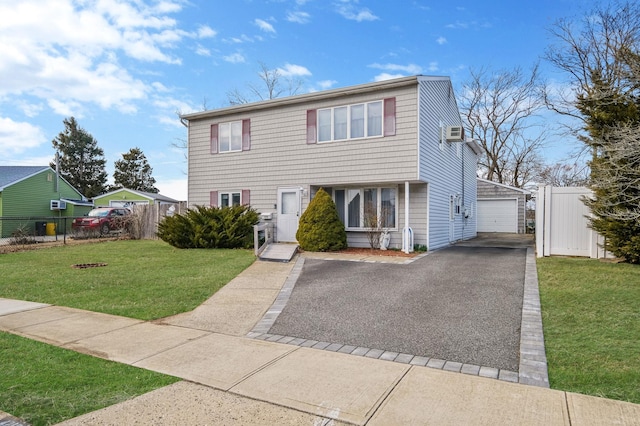 view of front of home featuring a front yard, fence, and a detached garage