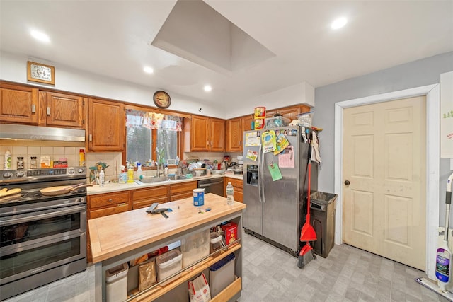 kitchen featuring light floors, stainless steel appliances, a sink, butcher block countertops, and under cabinet range hood