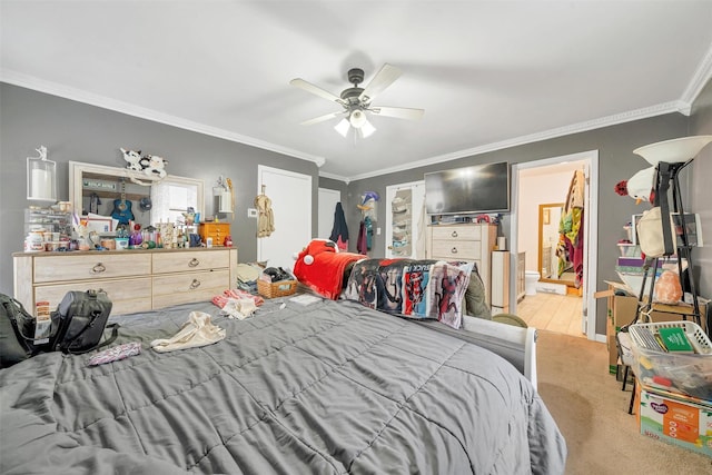 bedroom featuring ornamental molding, ensuite bathroom, and a ceiling fan