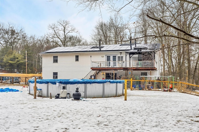 snow covered house with a covered pool and a deck