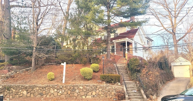 obstructed view of property featuring stairway and an outbuilding