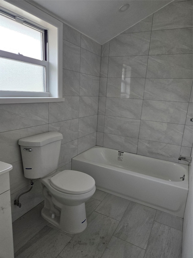 full bathroom featuring shower / bathing tub combination, tile walls, and toilet