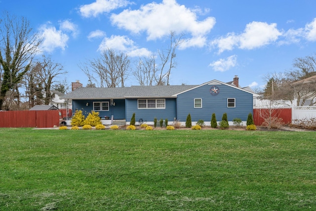 view of front of house featuring a chimney, a front yard, and fence