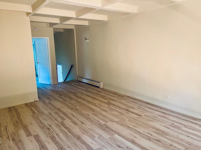 unfurnished room with a baseboard radiator, light wood-style flooring, and beam ceiling