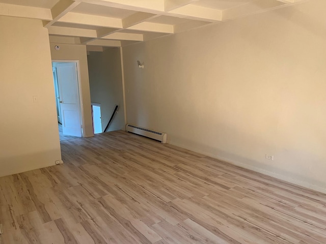 spare room with beam ceiling, a baseboard radiator, coffered ceiling, and light wood-style flooring