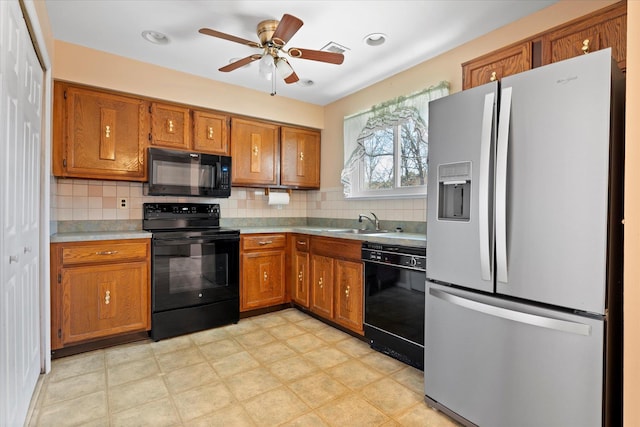 kitchen with brown cabinets, a sink, and black appliances