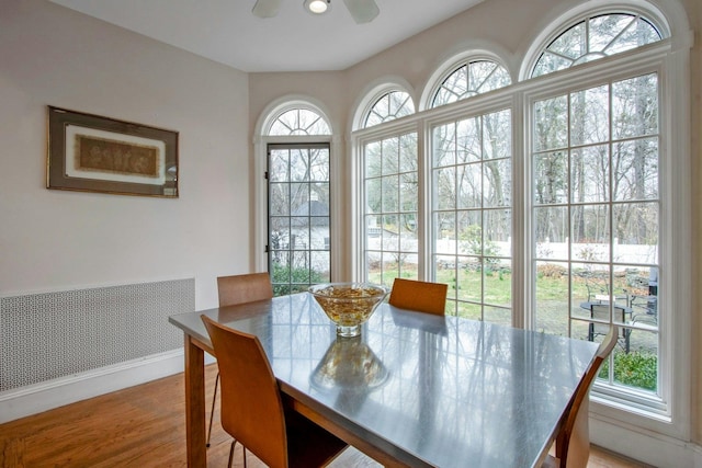 dining area with wood finished floors, ceiling fan, and baseboards