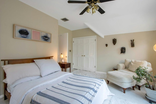 bedroom with a closet, light colored carpet, vaulted ceiling, visible vents, and baseboards