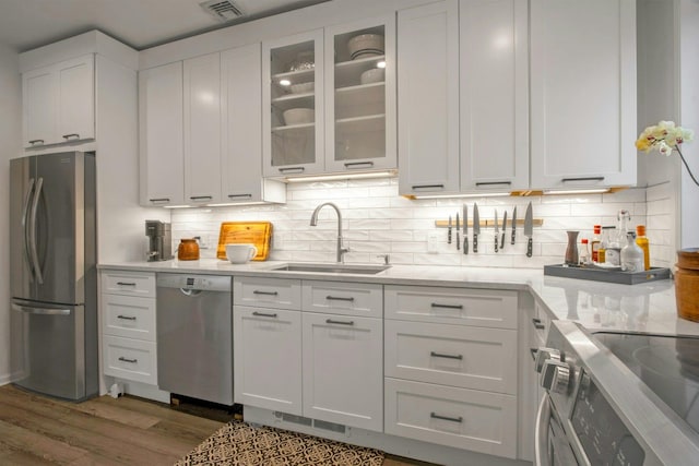 kitchen featuring visible vents, a sink, dark wood-style floors, white cabinetry, and stainless steel appliances