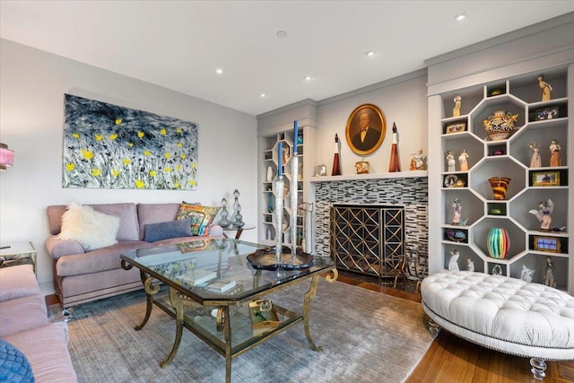 living area featuring recessed lighting, a tiled fireplace, and wood finished floors